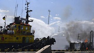 Pompieri al lavoro dopo un attacco missilistico russo al porto di Odessa.