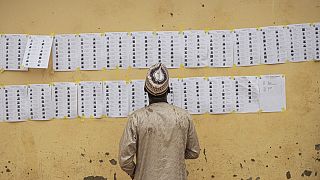 A voter looks for his name on the voters roll at a polling station in Abuja on February 25, 2023, during Nigeria's presidential and general election.