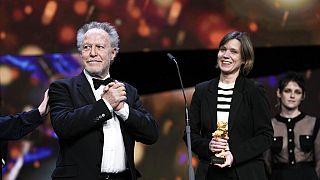 Nicolas Philibert, left, director of the documentary "Sur lAdamant" ("On the Adamant"), receives the Golden Bear for Best Film