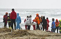 Rescuers recover a body at a beach near Cutro, southern Italy, after a migrant boat broke apart in rough seas, Sunday, Feb. 26, 2023.