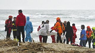 Rescuers recover a body at a beach near Cutro, southern Italy, after a migrant boat broke apart in rough seas, Sunday, Feb. 26, 2023.