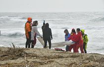 Rescuers recover a body after a migrant boat broke apart in rough seas, at a beach near Cutro, southern Italy, Sunday, Feb. 26, 2023cc