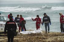 Rescuers recover a body at a beach near Cutro, southern Italy, after a migrant boat broke apart in rough seas.