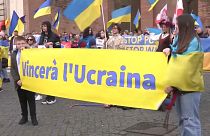 Ukrainian protesters in Rome hold up a banner in support of Ukrainian resistance against Russia