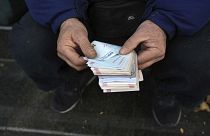 Iraniano conta notas de rial, a divisa iraniana