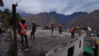 Laborers demolish a building which has developed cracks in Joshimath, in India's Himalayan mountain state of Uttarakhand.