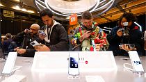 Visitors take pictures of Xiaomi 13 mobile phone models at the Xiaomi booth before the Mobile World Congress 2023 in Barcelona, Spain, on Sunday, Feb. 26, 2023