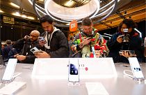 Visitors take pictures of Xiaomi 13 mobile phone models at the Xiaomi booth before the Mobile World Congress 2023 in Barcelona, Spain, on Sunday, Feb. 26, 2023