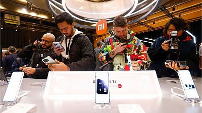 Visitors take pictures of Xiaomi 13 mobile phone models at the Xiaomi booth before the Mobile World Congress 2023 in Barcelona, Spain, on Sunday, Feb. 26, 2023
