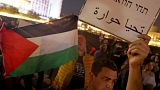 متظاهر إسرائيلي يرفع ورقة كتب عليها "تحيا حوارة" 