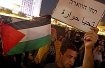 متظاهر إسرائيلي يرفع ورقة كتب عليها "تحيا حوارة"