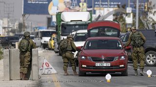 جنود إسرائيلون يفتشون سيارة فلسطينية عند معبر أريحا
