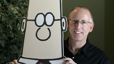 Scott Adam’s poses with his cartoon creation Dilbert 