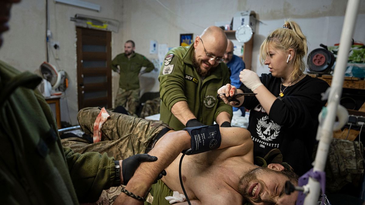 Médicos militares ucranianos atienden a su compañero herido en el hospital de campaña cerca de Bakhmut, Ucrania, domingo 26 de febrero de 2023. 