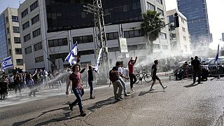 La policía israelí despliega un cañón de agua para dispersar a los manifestan que bloquean una carretera, en Tel Aviv, 1 de marzo de 2023