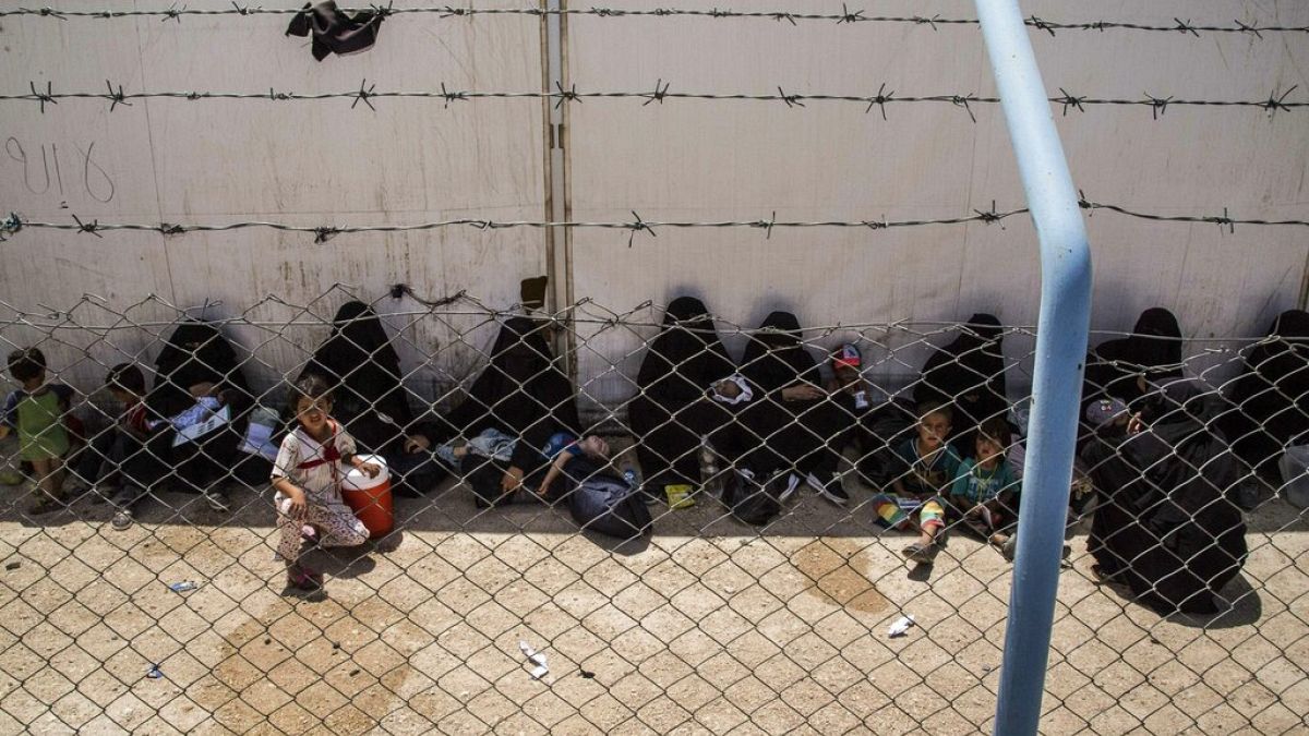 IŞİD savaşçılarının yakını kadın ve çocuklar evlerine gitmek üzere otobüs ve kamyonlara binmek için bekliyor