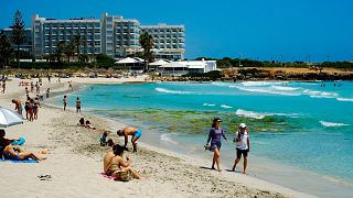 Os turistas desfrutam da popular Praia de Nissi na estância sudeste de Ayia Napa, no Chipre