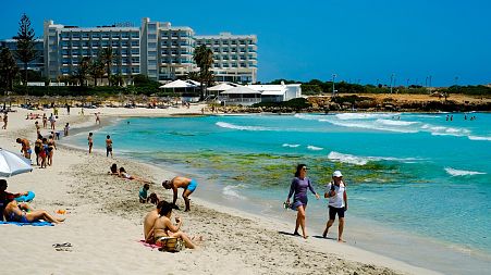 Tourists enjoy the popular Nissi Beach in southeast resort of Ayia Napa.