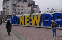 Kosovan Albanians walk past the newborn monument changed to "No New Broken Republic" in Pristina on February 27, 2023.