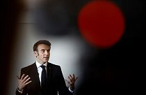 Macron gestures as he talks with schoolchildren in a classroom in Jarnac on February 28, 2023.