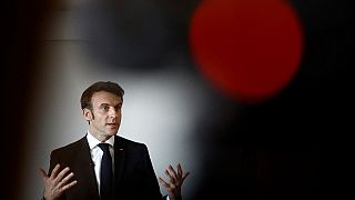 Macron gestures as he talks with schoolchildren in a classroom in Jarnac on February 28, 2023.