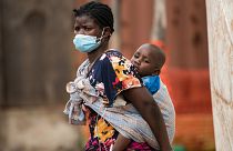 أم تحمل طفلها على ظهرها في ملاوي، أحد أكثر البلدان فقرا وأقلها تطورا في العالم