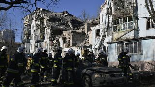 Bombeiros junto a edifício destruído em Zaporíjia