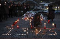 Una niña enciende una vela, en memoria de las víctimas de la colisión de trenes, frente a la estación de tren de Larissa, al norte de Atenas, Grecia, el 2 de marzo de 2023.