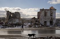 Une femme passe devant un bâtiment détruit par une frappe russe à Kupiansk, en Ukraine, le lundi 20 février 2023