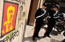 Police office outside Palermo University's School of Law, Sicily where graffiti portraying fugitive Mafia boss Matteo Messina Denar was found.