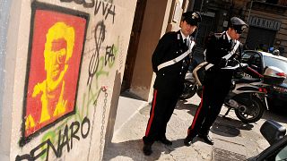 Police office outside Palermo University's School of Law, Sicily where graffiti portraying fugitive Mafia boss Matteo Messina Denar was found.