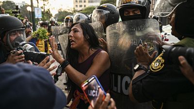 A demonstrator shouts next to riot police during a protest against the government of Peru's President Dina Boluarte.