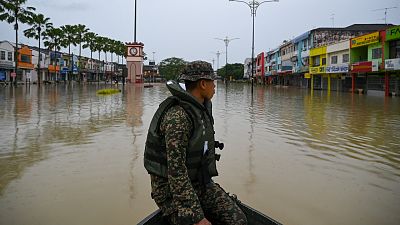 A Malaysian soldier looks out over flood waters in Kota Tinggi, Malaysia's Johor state. 