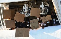 Migrants hold banners asking for help, from a deck of the Norway-flagged Geo Barents ship operated by Doctors Without Borders, in Catania's port, Sicily in 2022.