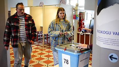 Varias personas caminan para depositar su voto en un colegio electoral durante las elecciones parlamentarias en Tallin, Estonia, el viernes 3 de marzo de 2023.