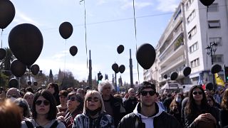 Fekete léggömbökkel gyászoló emberek Athénban 2023. március 5-én