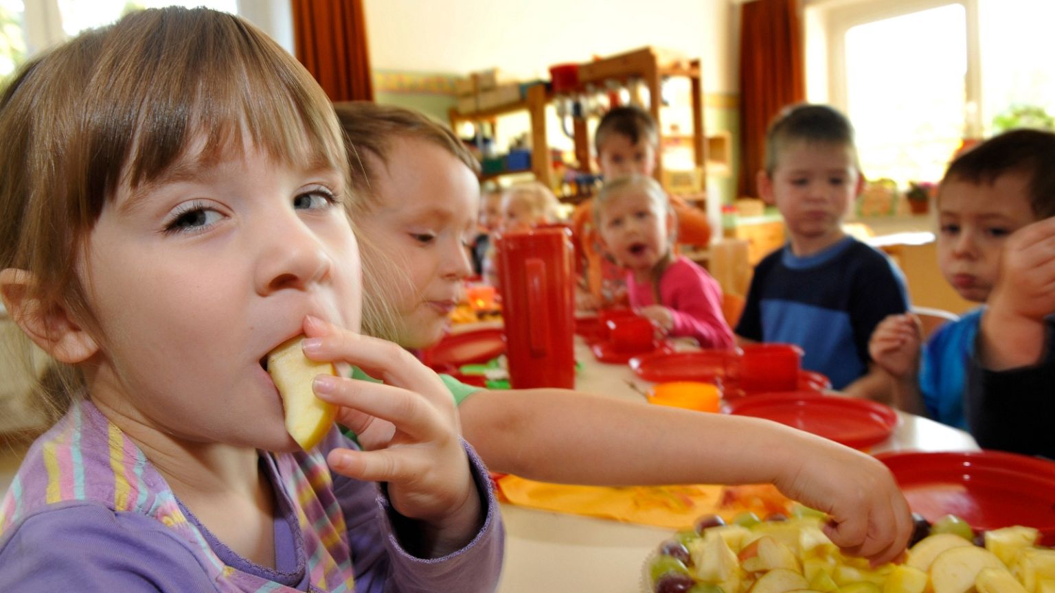 Emely, left, and other children have breakfast at a Kita, 7 October, in Grimma, Saxony. 