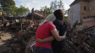 Две украинки перед разрушенным домом
