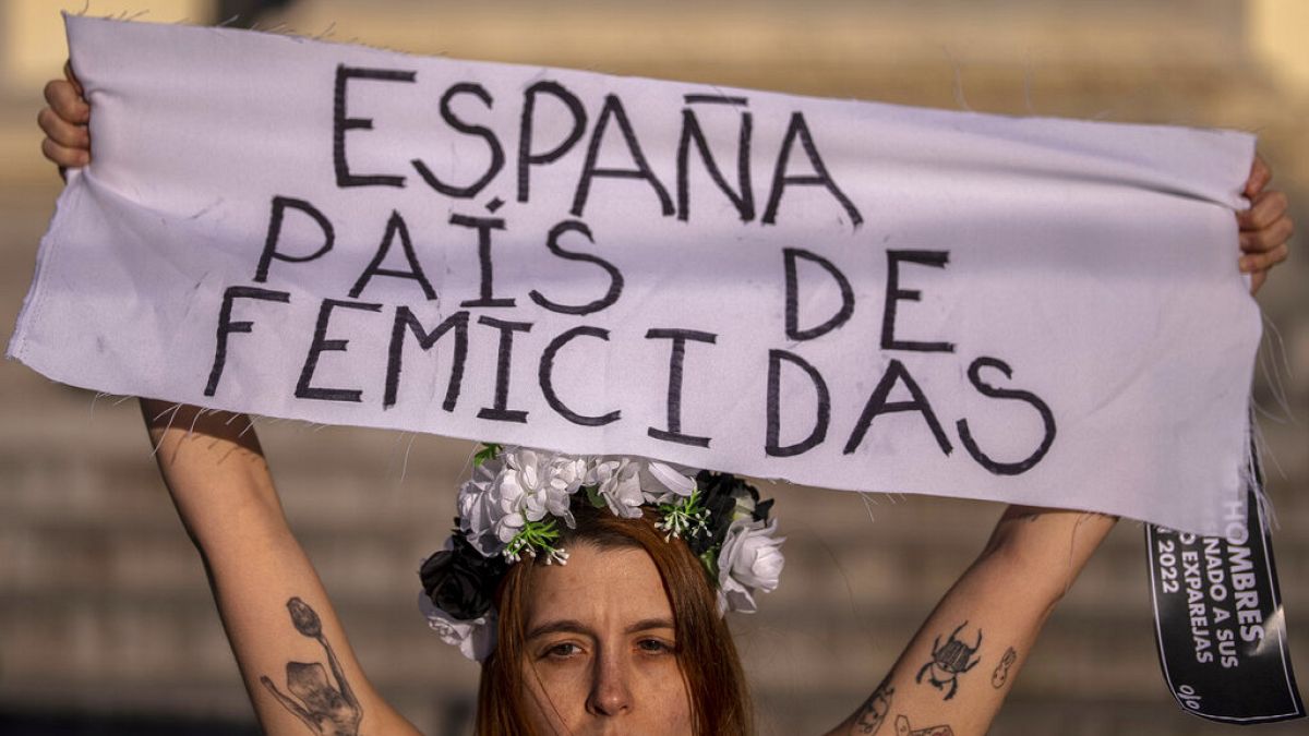 Egy tüntető "Spanyolország a nőgyilkosságok országa" feliratú molinót tart egy tüntetésen - képünk illusztráció