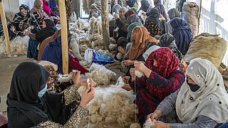 Illusztráció: afgán nők szőnyegszövéshez készítenek elő szálakat