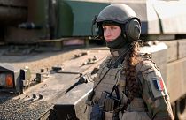 A French servicewoman, member of a Leclerc main battle tank crew attends an exercise involving HIMARS and MLRP rocket launchers at a firing range in Capu Midia in Romania.