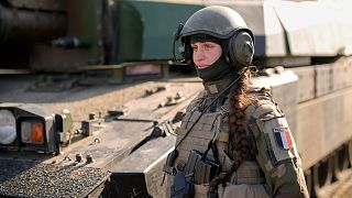 A French servicewoman, member of a Leclerc main battle tank crew attends an exercise involving HIMARS and MLRP rocket launchers at a firing range in Capu Midia in Romania.
