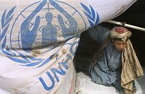  لاجئ أفغاني يساعد في تفريغ المساعدات الإنسانية التي قدمتها مفوضية الأمم المتحدة لشؤون اللاجئين إلى مخيم مينارا، في ضواحي مدينة هرات بغرب أفغانستان، 23 نوفمبر 2001.
