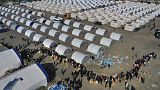 أشخاص فقدوا منازلهم في الزلزال المدمر، يصطفون لتلقي إمدادات المساعدات في مخيم مؤقت في الإسكندرونة، جنوب تركيا، 14 فبراير 2023.