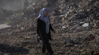 Egy nő sétál Antakya utcáin a földrengést követően