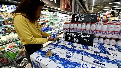 FILE: Woman examining food items on a supermarket shelf displaying product prices in both Kuna and Euro currency, in Zagreb, September 26, 2022