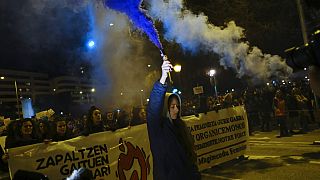A woman holds a flare while taking part in a demonstration on International Women's Day, in northern Spain