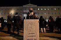 Женщина с плакатом перед греческим парламентом в Афинах во время демонстрации протеста в связи с железнодорожной катастрофой у Темпе. 3 марта 2023 года