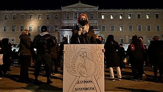 Женщина с плакатом перед греческим парламентом в Афинах во время демонстрации протеста в связи с железнодорожной катастрофой у Темпе. 3 марта 2023 года