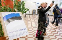 Varias personas se hacen fotos tras depositar su voto en un colegio electoral de la Universidad de Tallin.